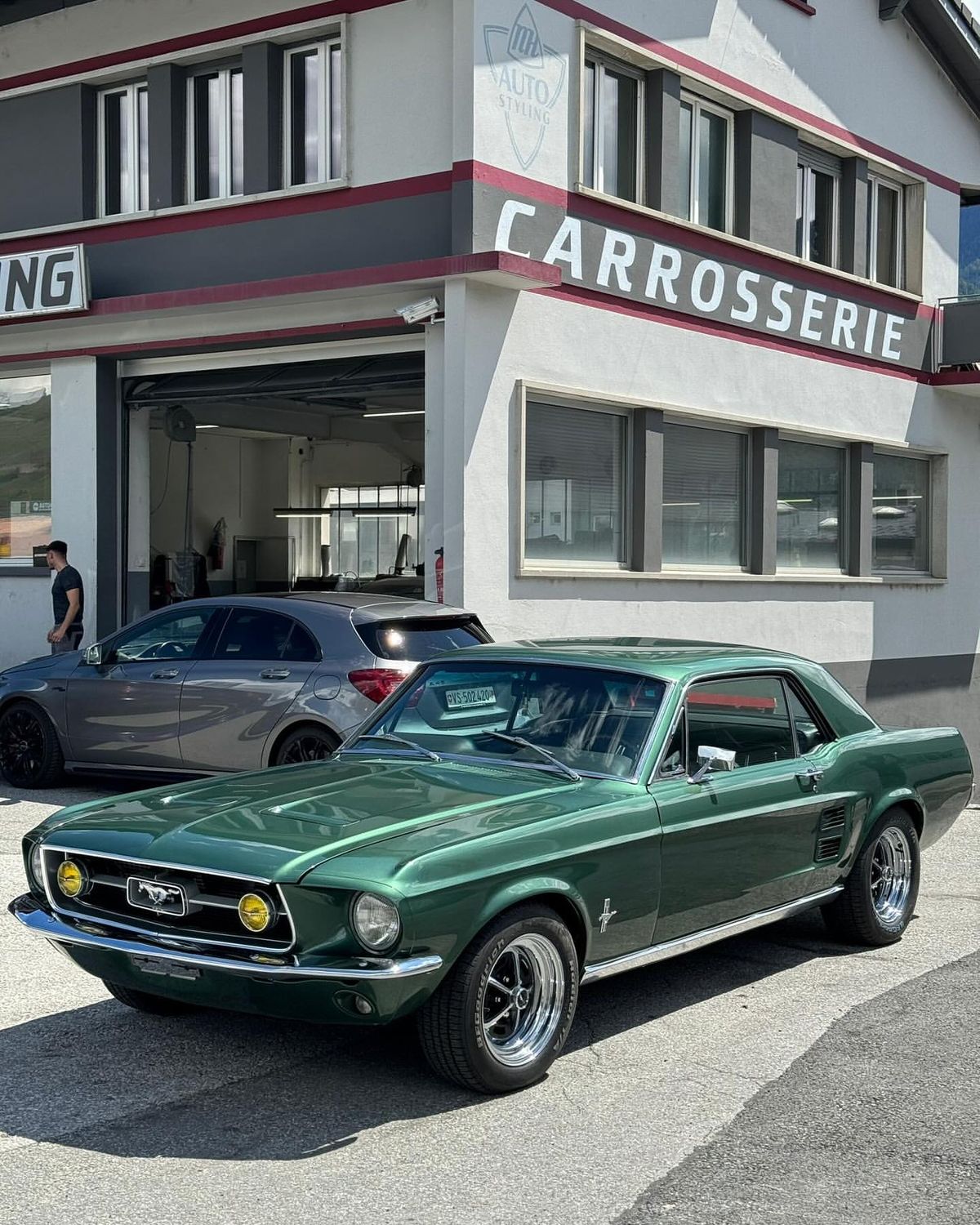Ford Mustang verte devant la carrosserie